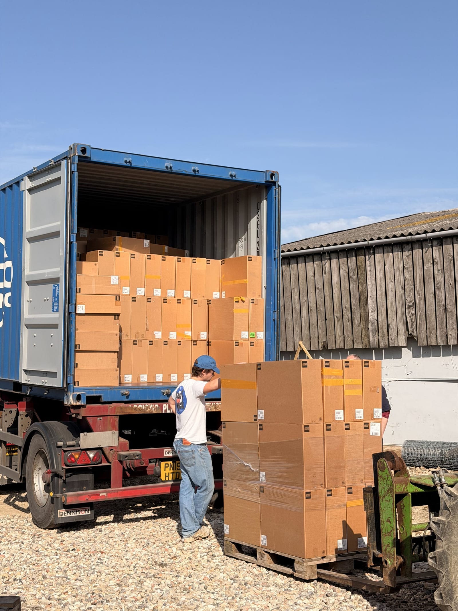A container of sealed LEGO sets being unloaded at the unit