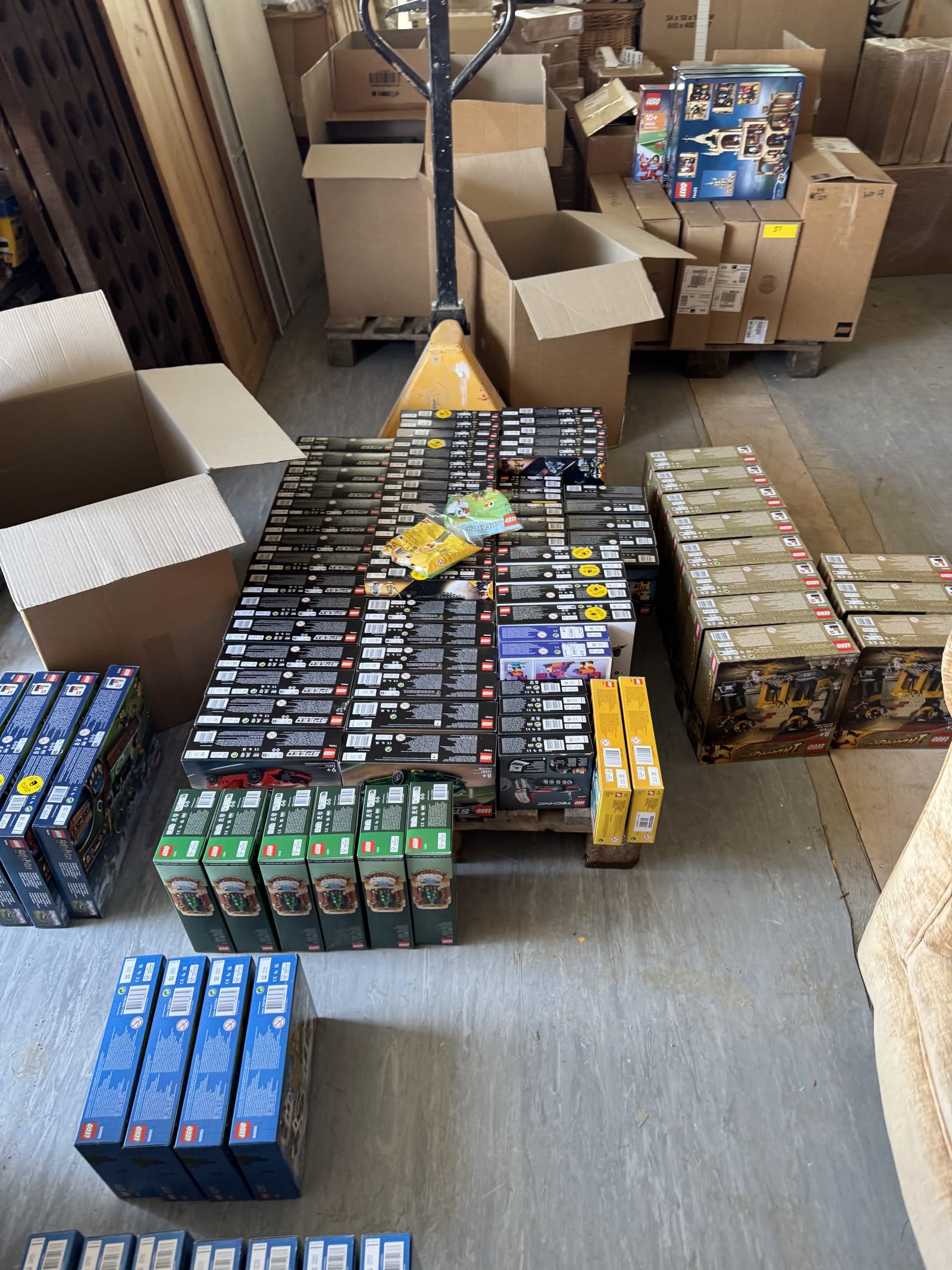 A collection of sealed LEGO sets laid out on the floor after collection