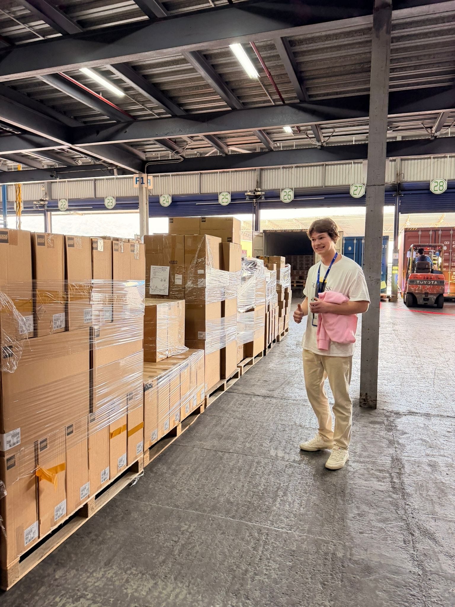 Peter beside pallets of sealed LEGO at the supplier